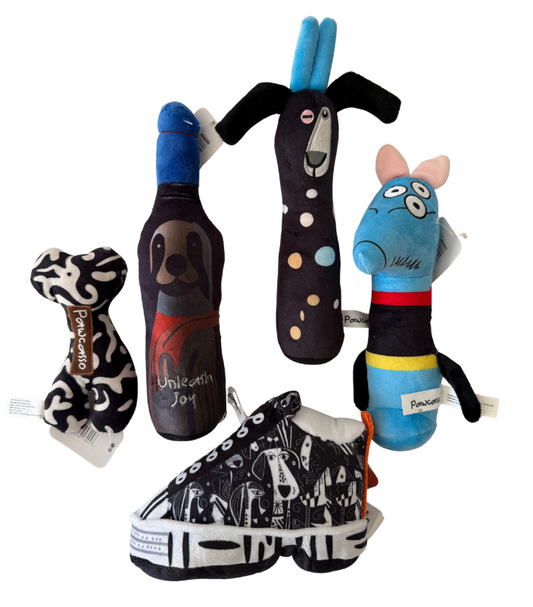 A set of Paw Patrol themed dog toys and a matching shoe, including a bone-shaped toy, a bottle-shaped toy, a tall pole toy, a blue character toy, and a black-and-white sneaker, all on a white background.